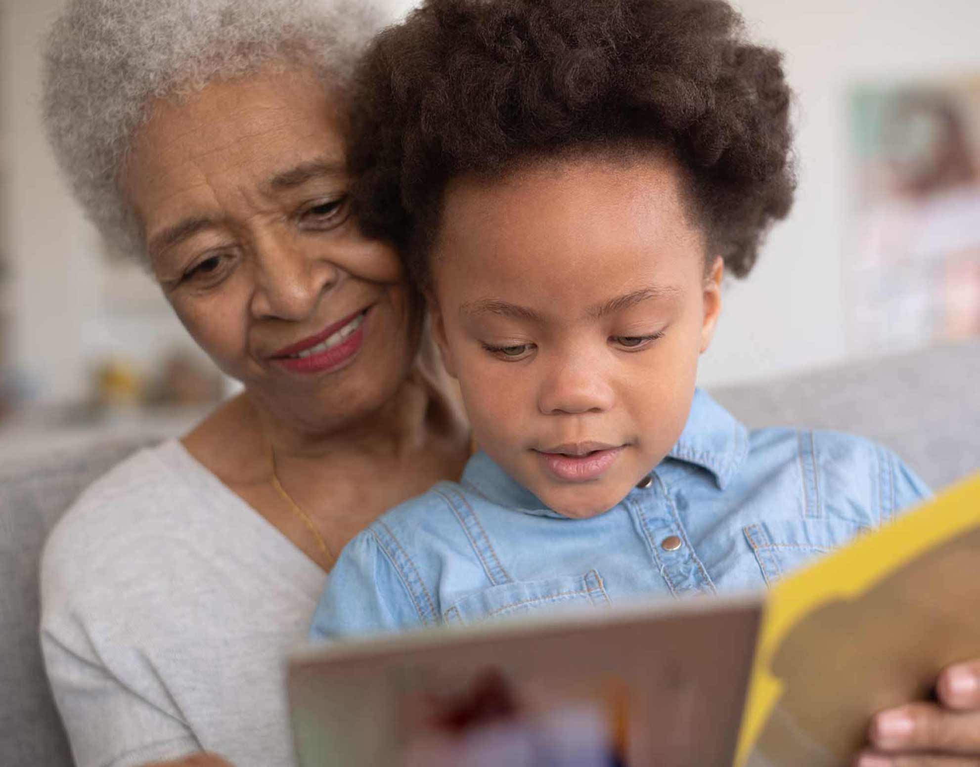 Photo of grandmother and her granddaughter reading a book