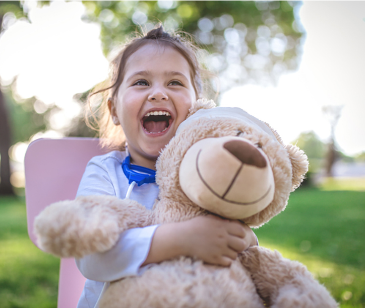 a little girl hugging a teddy bear